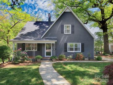 Charming home featuring landscaped front yard, covered porch, and inviting walkway at 848 Woodland Rd, Statesville, NC 28677