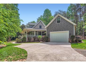 Charming two-story home with a welcoming front porch and a spacious driveway leading to an attached garage at 119 Taylor Ct, Mooresville, NC 28117