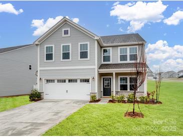 Charming two-story home with a well-manicured lawn, and a two car garage at 124 Benford Dr, Troutman, NC 28166