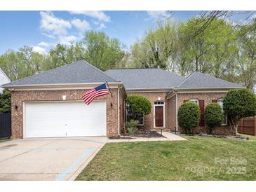 Charming brick home featuring an attached two-car garage, manicured lawn, and front entry at 147 Gabriel Dr, Mooresville, NC 28115