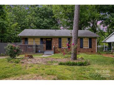 Charming brick home featuring a covered porch and well-maintained front yard, creating curb appeal at 1519 Briarfield Dr, Charlotte, NC 28205