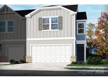New two-story home with a two-car garage and beautiful light gray vinyl siding at 1730 Braemar Village Dr, Monroe, NC 28110