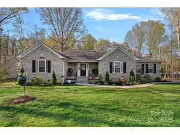 Charming brick ranch home with manicured lawn, mature trees, and welcoming front entry at 235 Stafford Estates Dr, Salisbury, NC 28146