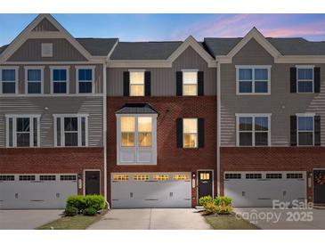 Charming townhome with brick facade, gray siding, and a one-car garage offers comfortable living at 2619 Grantham Place Dr, Fort Mill, SC 29715