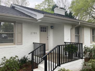Charming front entrance with black railings, brick facade, and neutral door at 2701 Rea Rd, Charlotte, NC 28226