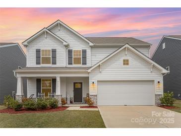 Charming two-story home with gray shutters, a covered porch, an attached garage and colorful twilight sky at 2893 Yeager Nw Dr, Concord, NC 28027
