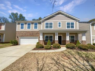 Charming two-story home featuring a brick and siding exterior, attached garage, and well-manicured front yard at 3026 S Devon St, Charlotte, NC 28213