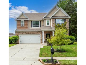 Charming two-story home featuring a brick facade, well-manicured lawn, and attached two-car garage at 4924 Riverdale Dr, Charlotte, NC 28273