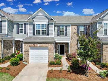 Charming townhome with a one-car garage and beautifully landscaped front yard at 526 Hunters Dance Rd, Fort Mill, SC 29708