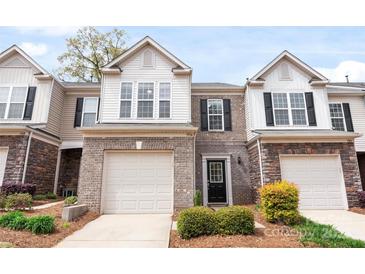 Charming townhome featuring brick accents, a one-car garage, and neatly maintained landscaping in a desirable community at 5924 Carrollton Ln, Charlotte, NC 28210
