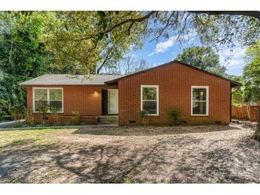 Charming brick home featuring large windows and a well-maintained front yard at 900 E Woodlawn Rd, Charlotte, NC 28209