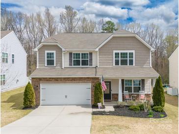 Charming two-story home with a well-manicured lawn, a two-car garage, and a welcoming front porch at 10694 Sapphire Trl, Davidson, NC 28036