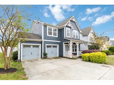 Charming two-story home with a two car garage, well-maintained lawn, and light blue siding at 12706 Ballyliffin Dr, Pineville, NC 28134