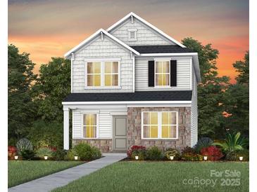 Charming two-story home with stone accents, a manicured lawn, and lovely landscaping at 15942 Parkside Crossing Dr # 326, Charlotte, NC 28273