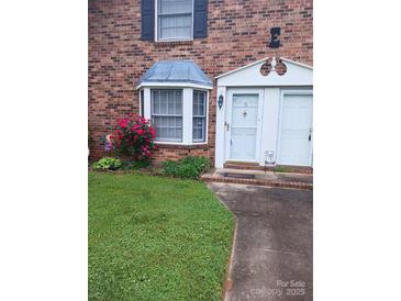 Charming brick townhouse featuring a bay window and well-manicured lawn at 160 17Th Street Nw Pl # 3E, Hickory, NC 28601