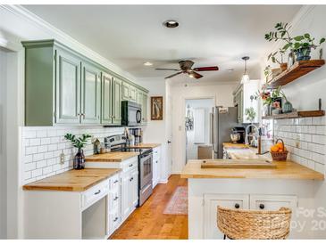Bright kitchen features custom sage cabinets, butcher block countertops, stainless appliances, and stylish decor at 2175 Highwood Rd, Rock Hill, SC 29732