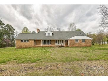 Traditional brick ranch home with a covered front porch and mature landscaping on a cloudy day at 2705 Robinson Rd, Newton, NC 28658