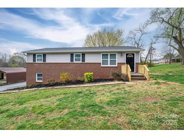 Charming split-level home featuring a brick facade and recently stained wooden porch with lush front yard at 3791 Richard St, Claremont, NC 28610