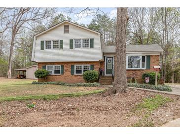 Charming two-story home with brick facade, green shutters, and a landscaped front yard at 4603 Oakwood Cir, Gastonia, NC 28056
