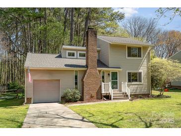 Two-story home with garage, brick chimney, and well-maintained lawn and driveway at 8224 Park Vista Cir, Charlotte, NC 28226