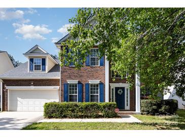 Charming brick two-story home with blue shutters, a well-kept lawn, and attached two-car garage at 10429 Madison Park Dr, Charlotte, NC 28269