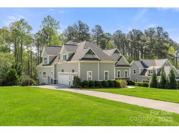 Charming two-story home boasts lush landscaping, attached garage and well manicured lawn at 125 Trent Pines Dr, Mooresville, NC 28117