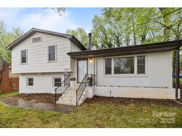 Charming two-story home featuring a white brick facade, black trim, and inviting front steps at 1801 Weststone Dr, Charlotte, NC 28208