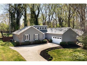 Charming gray home with a long driveway and manicured lawn in a wooded setting at 3489 Lake Shore S Rd, Denver, NC 28037