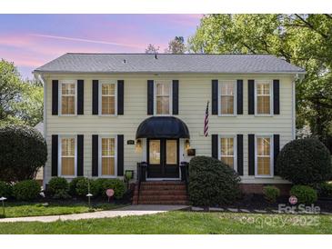 Charming yellow two-story house with black shutters and a well-manicured front yard at 3916 Riverbend Rd, Charlotte, NC 28210