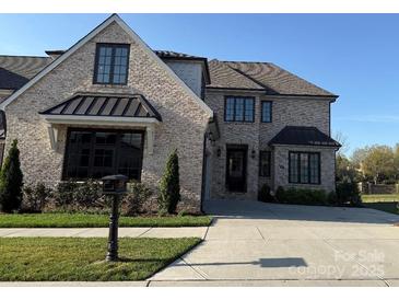 Beautiful brick home featuring a manicured lawn, black window trim and black awning detail over the front window at 4155 Persimmon Rd, Lancaster, SC 29720