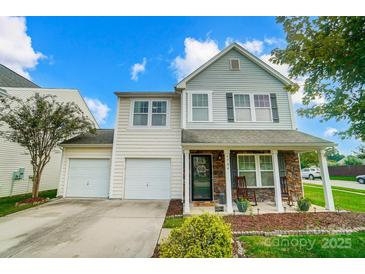Two-story home featuring a two-car garage, stone accents, and landscaped front yard at 9704 Cayenne Dr, Charlotte, NC 28214