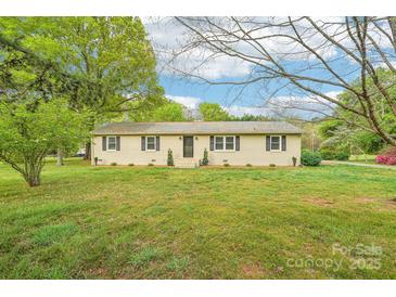Charming one-story home with a well-manicured front lawn and mature trees, providing a welcoming curb appeal at 9907 Hagers Rd, Huntersville, NC 28078