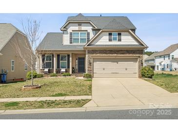 Charming two-story home featuring a stone facade, covered porch, and attached two-car garage at 110 Lantern Acres Dr, Mooresville, NC 28115