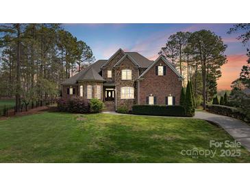 Charming two-story brick and stone home with lush landscaping and a well-manicured lawn at 116 Whispering Cove Ct, Mooresville, NC 28117