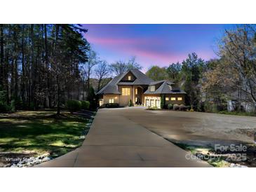 Stately home with a long driveway and 2 car garage surrounded by manicured landscaping at 1754 Brawley School Rd, Mooresville, NC 28117