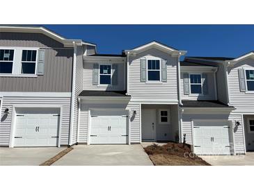Charming townhome with white siding, attached garage, and well-maintained landscaping at 2060 Old Rivers Rd, Concord, NC 28027