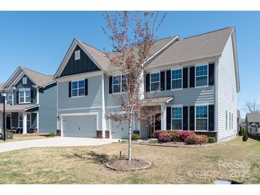 Charming two-story home with gray siding, black shutters, and a well-manicured front yard at 2097 Saddlebred Dr, Iron Station, NC 28080