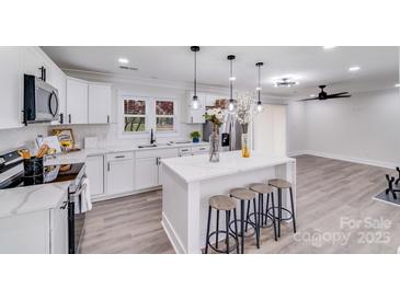 Modern kitchen featuring white cabinets, a center island, and stainless steel appliances at 2109 Tarlton Dr, Matthews, NC 28105