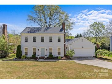 Charming two-story home featuring a well-manicured lawn, attached garage, and classic colonial architecture under a blue sky at 9637 Stoney Hill Ln, Charlotte, NC 28277