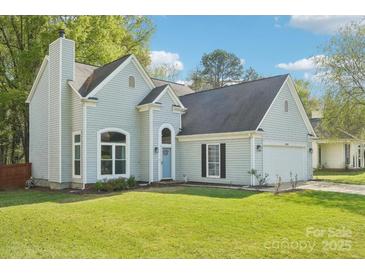 Charming home with blue siding, well-manicured lawn and attached two car garage at 14130 Misty Brook Ln, Charlotte, NC 28273