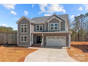 Charming two-story home with gray siding, white trim, covered entrance, and an attached two-car garage at 143 Mills Garden Rd, Statesville, NC 28625