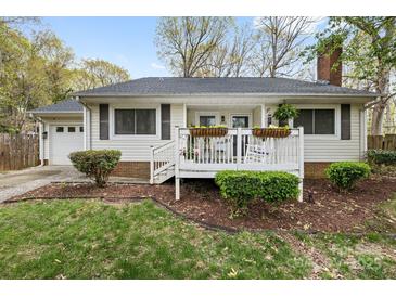 Charming single-story home featuring a welcoming front porch with flower boxes and a well-maintained yard at 1555 Ridgewood Dr, Gastonia, NC 28054
