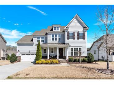 Beautiful two-story home with a well-manicured lawn and attached two-car garage on a sunny day at 345 Somerled Way, Waxhaw, NC 28173