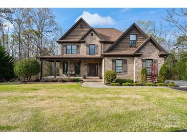 Charming two-story brick home with a well-manicured lawn and inviting covered front porch at 4231 Brushy Knl, York, SC 29745