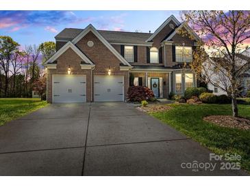 Charming two-story brick home with a manicured lawn and a two-car garage, perfect for Gathering living at 5854 Crimson Oak Ct, Harrisburg, NC 28075