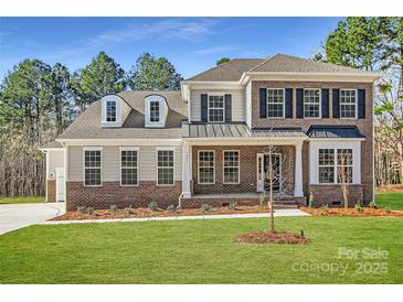 Charming two-story home showcasing a manicured lawn and brick and siding facade at 7005 New Town Rd, Waxhaw, NC 28173