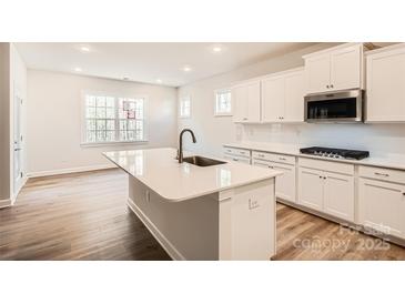 Bright kitchen with a large island, stainless steel appliances, and a view to the backyard at 7005 New Town Rd, Waxhaw, NC 28173