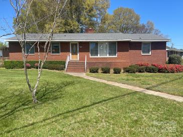 Charming brick home with a well-manicured lawn and colorful shrubbery at 701 Dakota St, Kannapolis, NC 28083