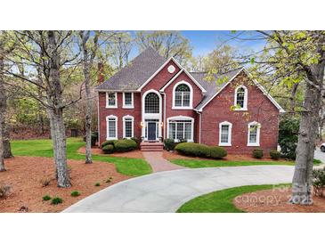 Beautiful brick home with manicured lawn, mature trees, and a winding driveway leading to a stately entrance at 101 Saddletree Rd, Lincolnton, NC 28092