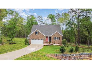 Charming brick home with attached garage, long driveway, and well manicured lawn at 1027 Williamston Dr, Marshville, NC 28103